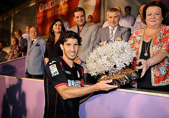 Diego Mainz, capitán del Granada en 2014, levanta el Trofeo del Olivo de dicha edición en el estadio de La Victoria.