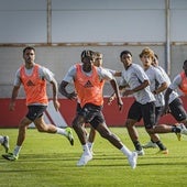 Varios futbolistas del primer equipo practican situaciones de ataque y defensa con centros laterales durante una sesión.