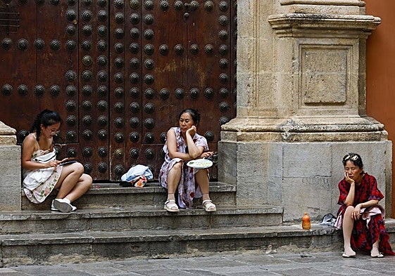 Tres turistas descansando en los escalones