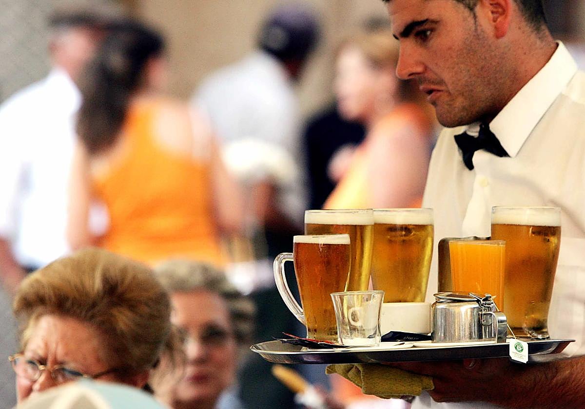 Un camarero sirve una comanda en una terraza.