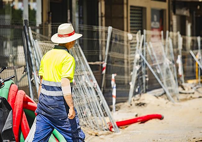 Un trabajador con un sombrero en una obra en el centro de Granada.
