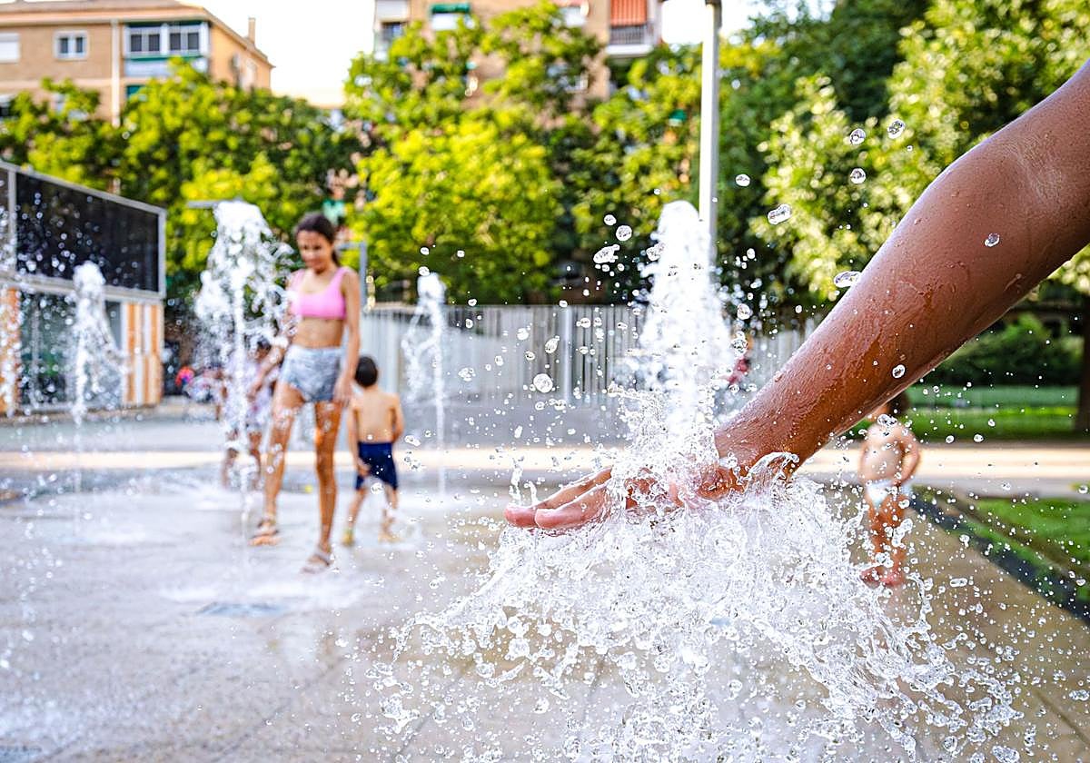 Los granadinos se refrescan en los chorros de agua de la Hípica en plena ola de calor.