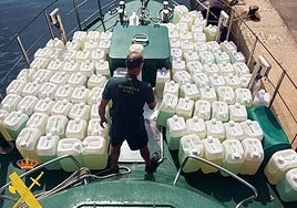 Un agente de Guardia Civil inspecciona garrafas de combustible intervenidas.