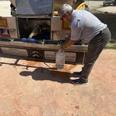 Un vecino llena una botella de agua del camión.