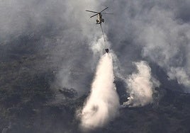 Un helicóptero combate el incendio que afectó a la Sierra de la Plata, en Tarifa (Cádiz).