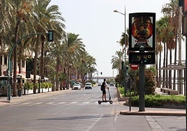 Un usuario de patinete cruza La Rambla con el mercurio a 44 grados.
