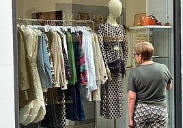 Una viandante contempla el escaparate de un comercio.