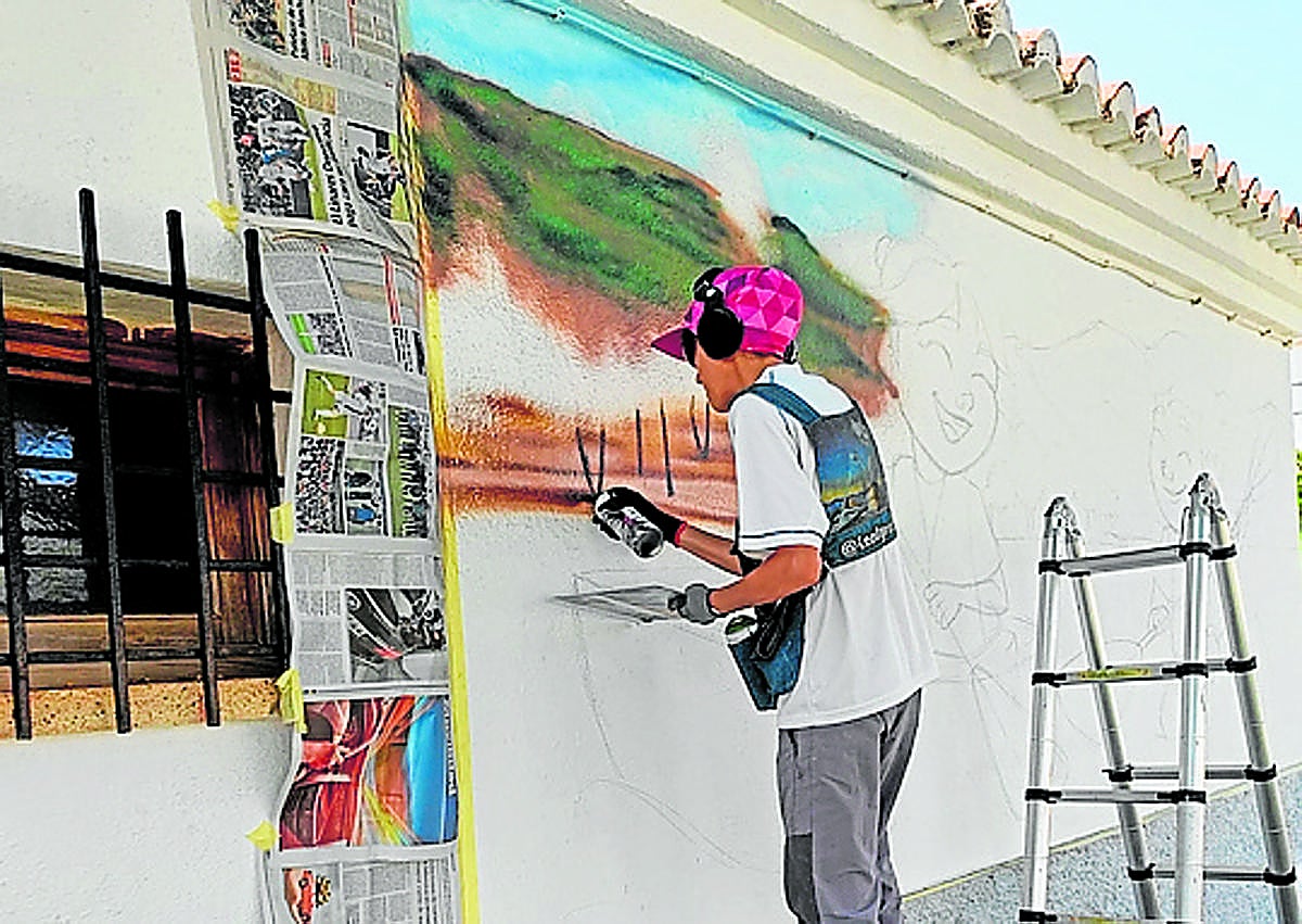 Imagen secundaria 1 - Icat y David Stone con su compinche pintan sus murales en diversos pueblos de Granada.
