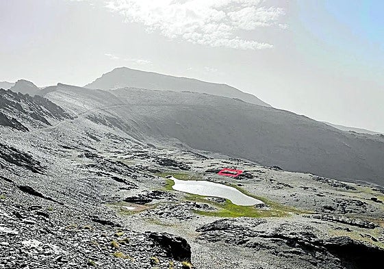 Vista de la laguna de Río Seco con el Mulhacén al fondo en una imagen tomada el 10 de agosto de 2025, con un recuadro que señala donde se situaba el refugio que fue demolido en la segunda mitad de los años 90.