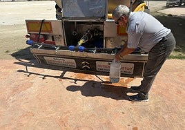 Un vecino recoge agua de un camión cisterna en la plaza del pueblo.