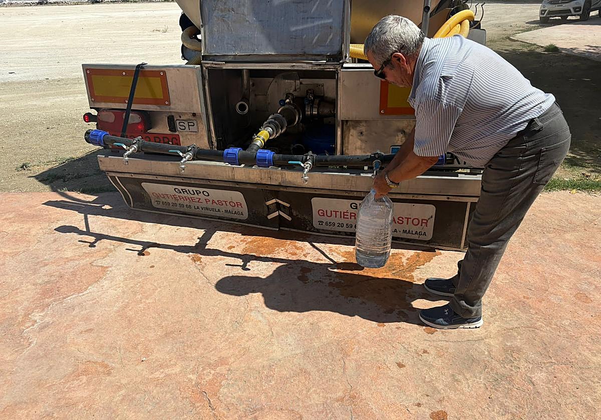 Un vecino recoge agua de un camión cisterna en la plaza del pueblo.