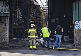 La inspectora de Trabajo, acompañada de bomberos, en la fábrica de aceite de Pinos Puente, nada más ser sofocado el incendio.