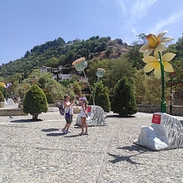 Una mujer fotografía a una niña junto a las flores