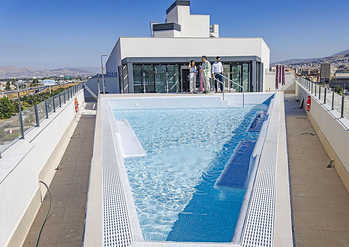 Imagen secundaria 1 - Juan Bascón y Enrique Molina en una de las habitaciones de Codomo y abajo la terraza con piscina y otra zona común, donde se están ultimando los detalles.
