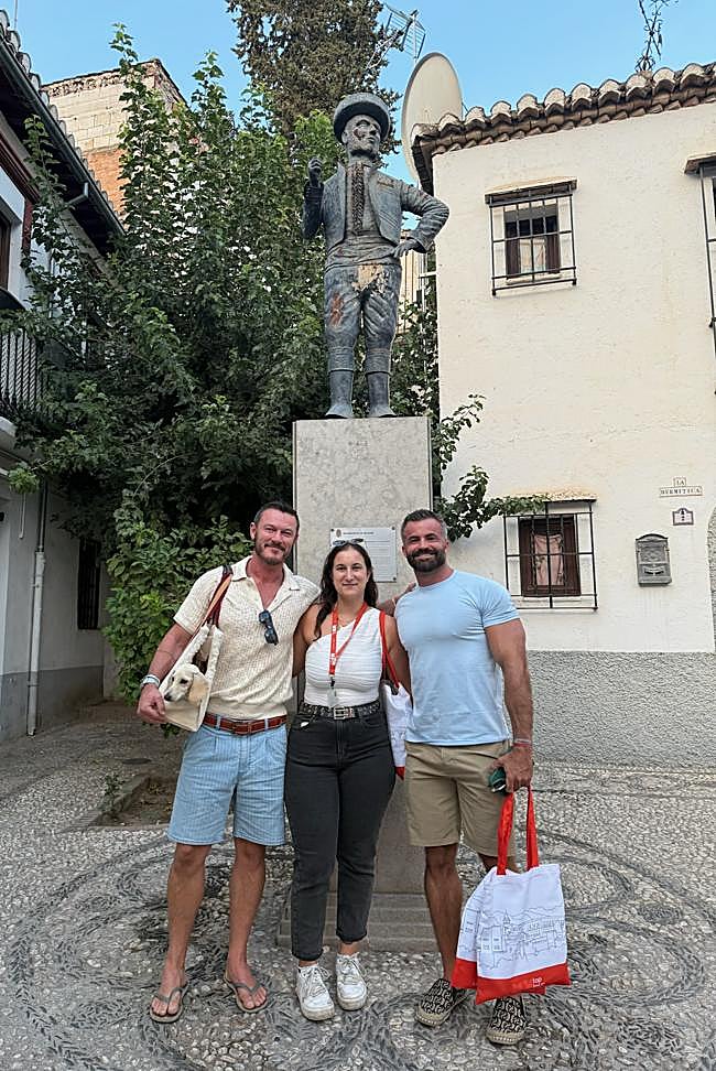 El actor Luke Evans y su pareja frente a la estatua de Chorrojumo.