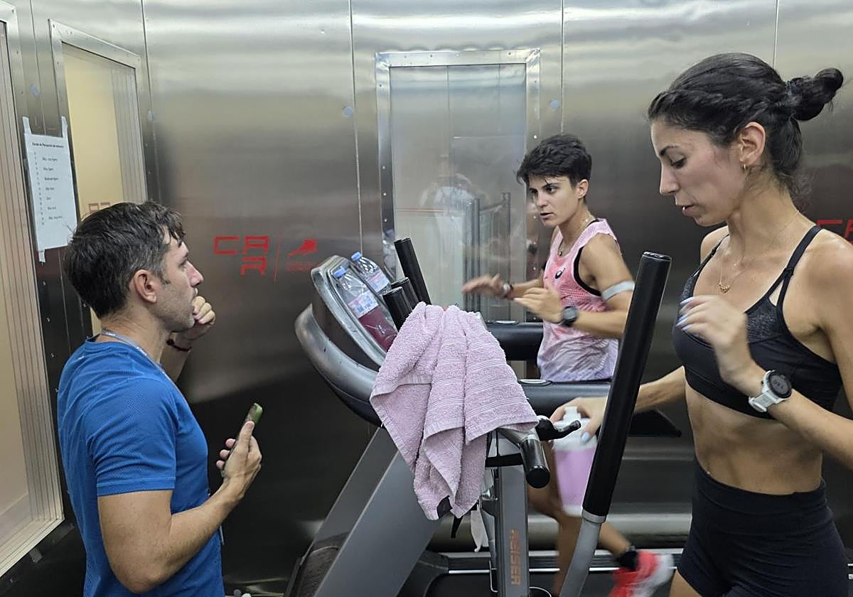 María Pérez escucha las indicaciones de su entrenador Jacinto Garzón con Cristina Montesinos a su lado en la cámara de calor del CAR de Sant Cugat.