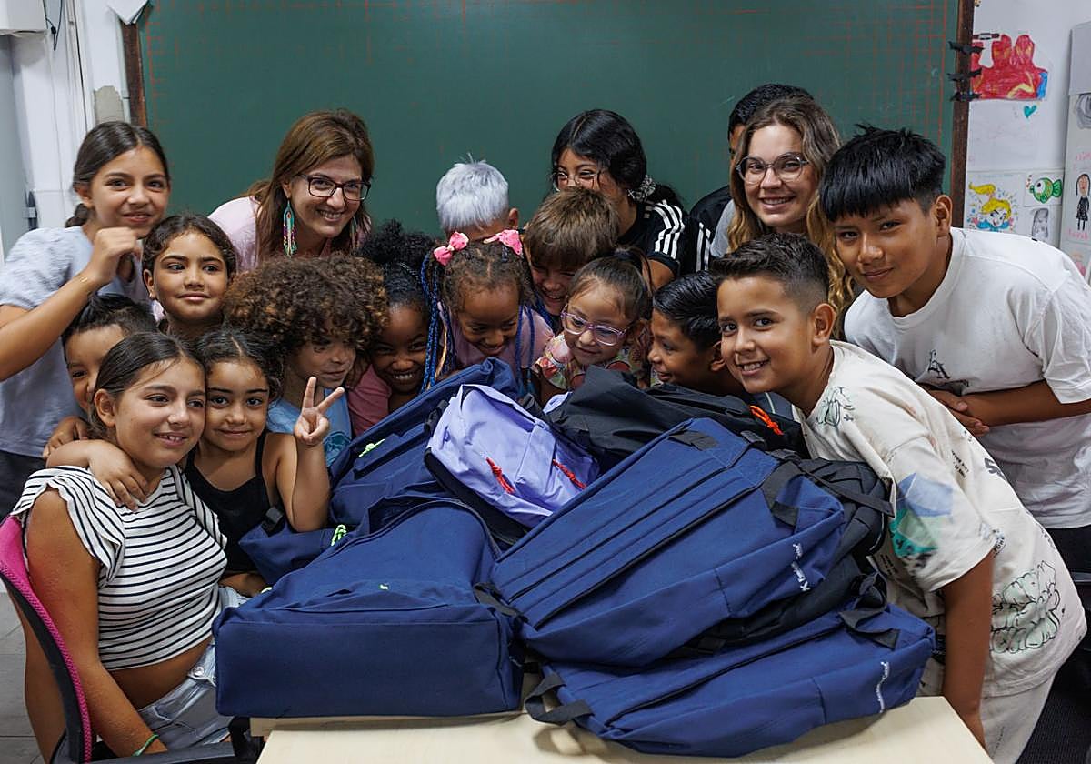 Niños y niñas con el material escolar para la vuelta al cole.