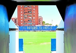 Salida del túnel de vestuario del estadio de Linarejos, con la gran lona en la grada de enfrente.