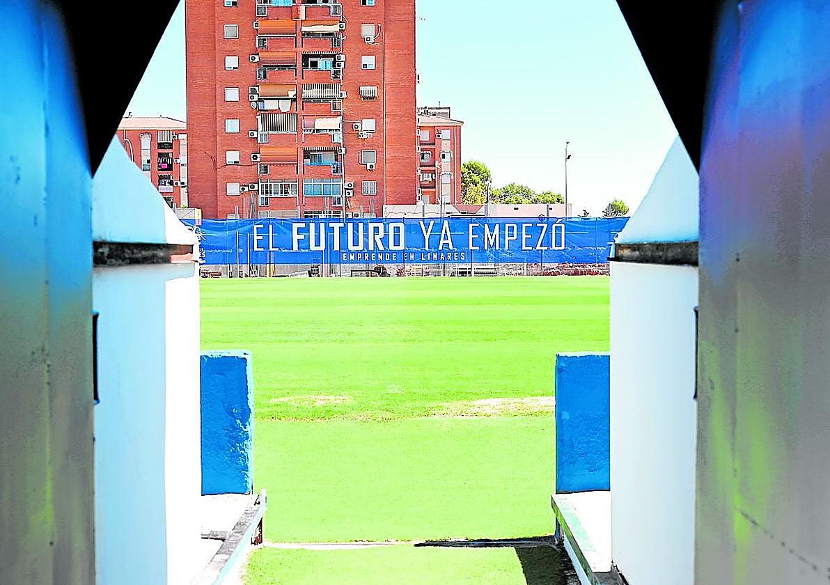 Salida del túnel de vestuario del estadio de Linarejos, con la gran lona en la grada de enfrente.