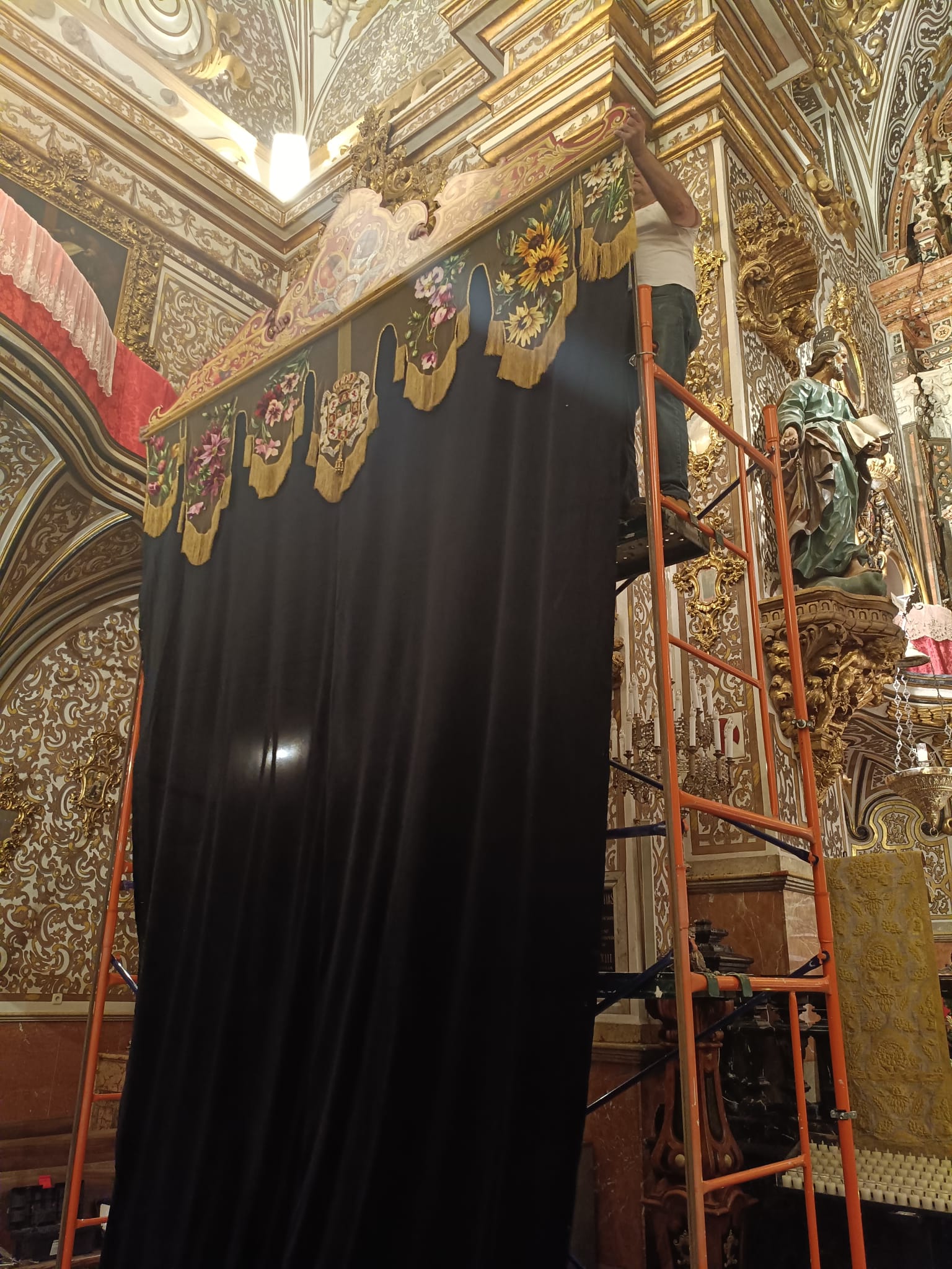 Los equipos de Priostía de la Virgen de las Angustias y del Señor de los Favores colocan el dosel del altar