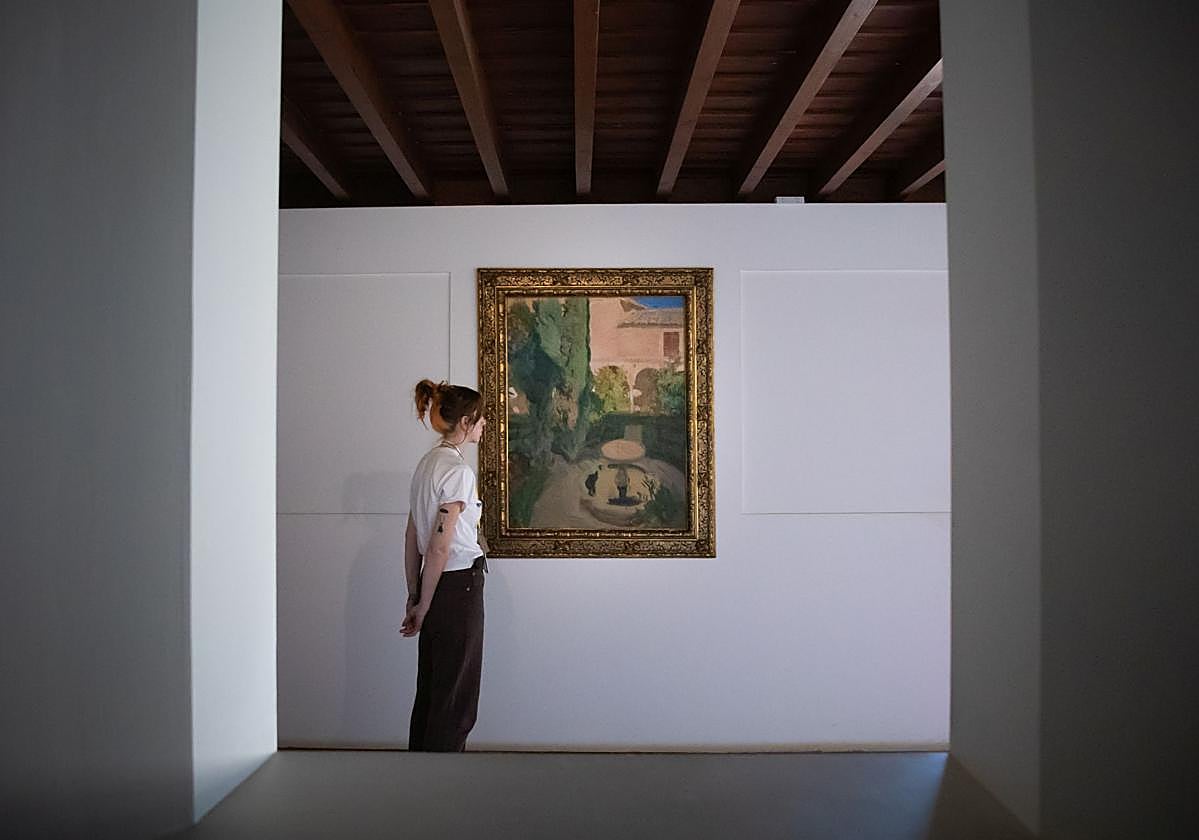 Visitante observa 'Jardín de Lindaraja', el cuadro de Sorolla que ha adquirido la Alhambra.