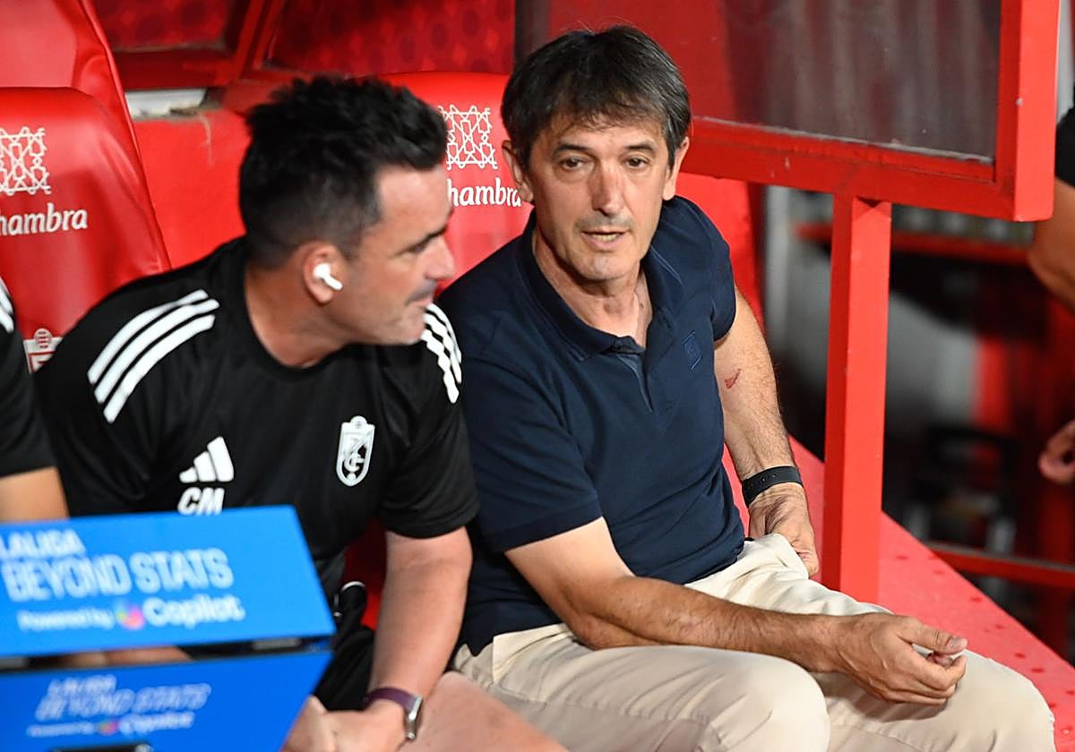 Pacheta charla con su segundo, Chema Monzón, sentados ambos en el banquillo de Los Cármenes.