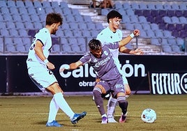 Samu Cortés intenta irse de dos futbolistas del Real Jaén.