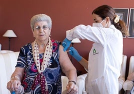Una enfermera vacuna a una mujer mayor en una residencia.