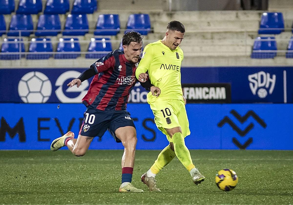 Hugo Vallejo, con la camiseta del Huesca, presiona a Escriche, en un partido contra el Cartagena.