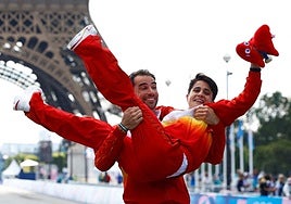 Gloria en París. Álvaro Martín eleva a María Pérez tras ganar conjuntamenteel relevo mixto de marcha.