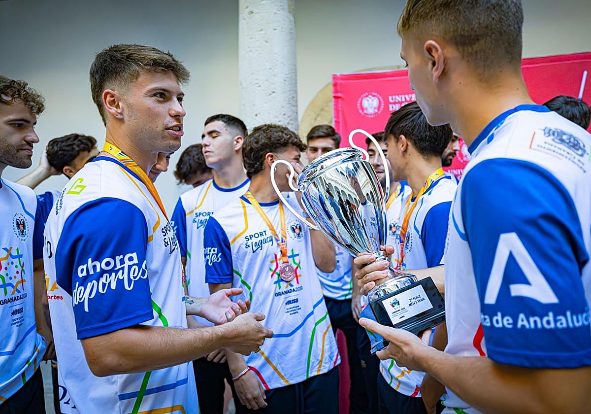 Los jugadores del equipo de fútbol masculino de la Universidad de Granada sostienen el trofeo al tercer puesto en el Mundial.