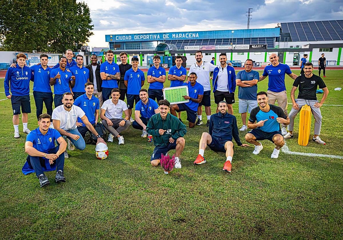 Los miembros de la plantilla del Maracena posan entre elementos identificativos de los oficios con los que compaginan el fútbol.
