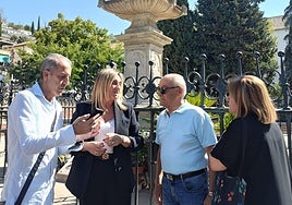 La alcaldesa de Granada, flanqueada por el presidente de la asociación del Realejo y un hermano de los Favores, escucha a una vecina.