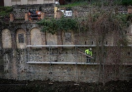 Trabajadores montan andamios en el lateral de la fábrica de cordeles, junto al hotel Reuma