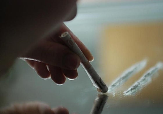 Una persona esnifa cocaína.