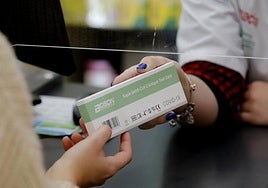 Una persona adquiere un test rápido de covid-19 en una farmacia.