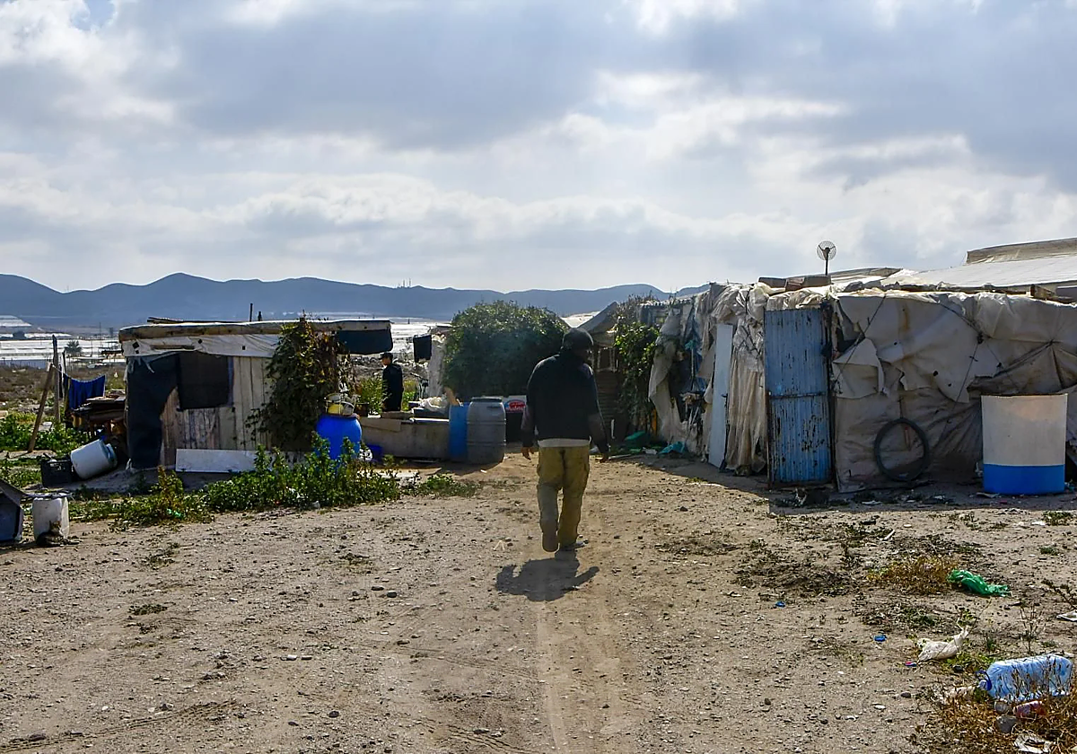 Una persona camina por el asentamiento del Cortijo El Uno de San Isidro, en Níjar.