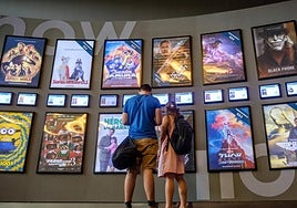 Una pareja contempla la cartelera de los cines Kinépolis