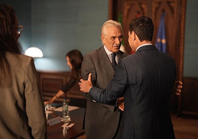 El presidente de la Junta, Juanma Moreno, saluda a los representantes de los enfermos de ELA a su llegada al encuentro.