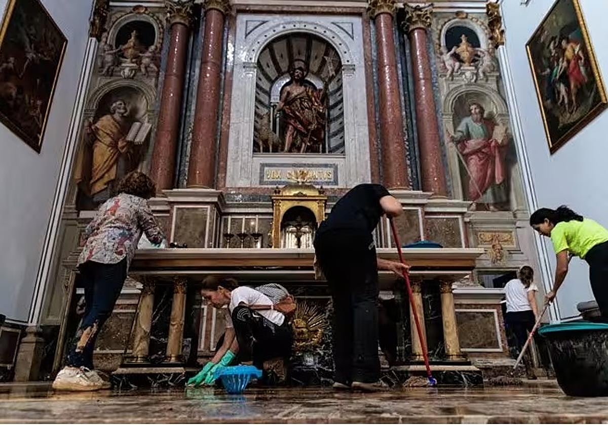 Varias personas trabajan en una iglesia afectada por la dana el pasado noviembre en Chiva