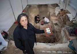 Carmen muestra la foto de su bisabuelo junto al sondeo donde se han hallado diez cadáveres en el cementerio del Padul.