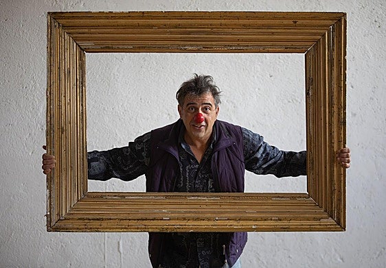 Piero, con su nariz roja, posa utilizando uno de los marcos que tienen de atrezzo en la escuela.