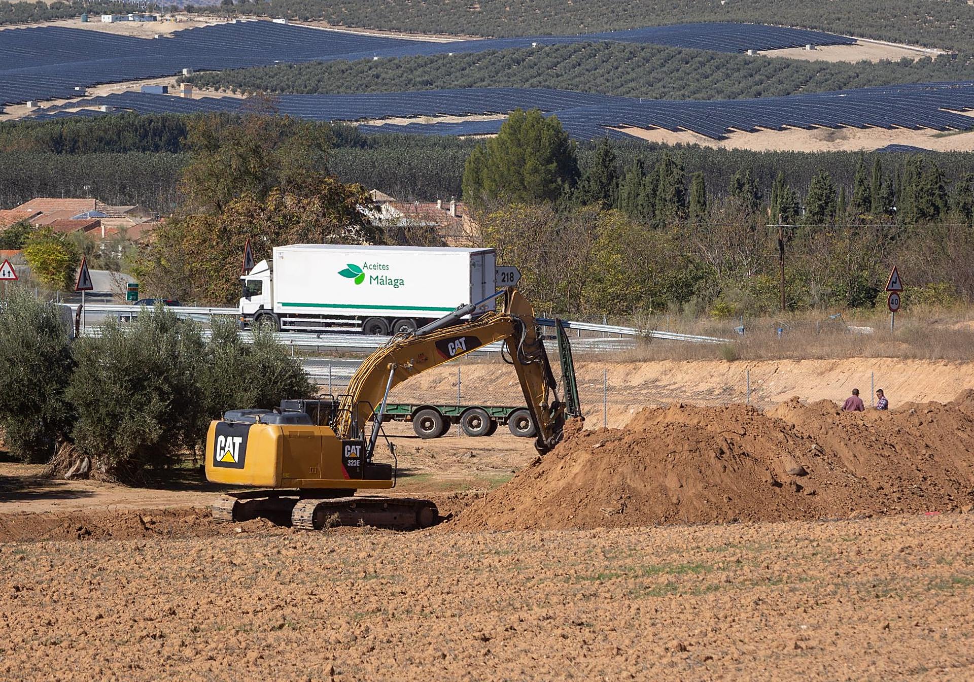 Excavadora limpiando arena en la parte que pega a la autovía.