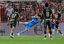 Ander Astralaga, de azul, se lanza a atajar un disparo del rival con el Granada.