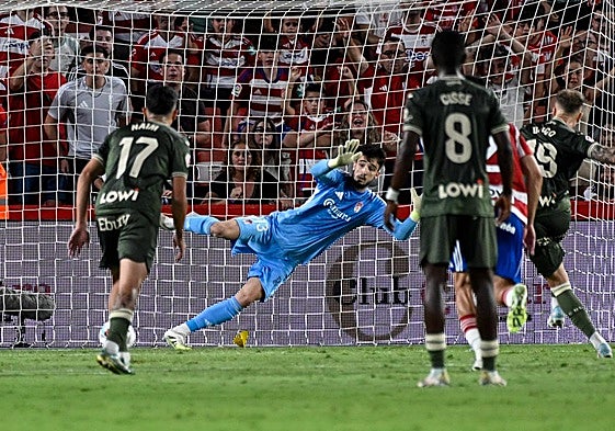 Ander Astralaga, de azul, se lanza a atajar un disparo del rival con el Granada.