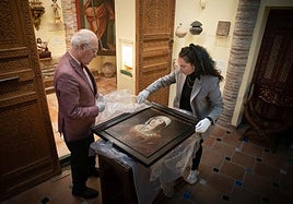 Carlos Ballesta y María Esperanza Pérez desenvuelven el cuadro de Isabel la Católica que ha adquirido la Fundación.