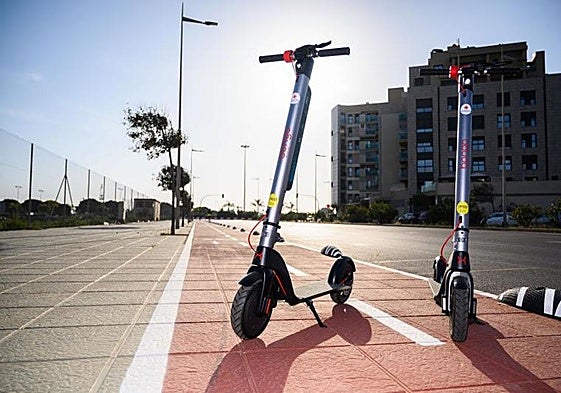 Dos patinetes en un carril bici