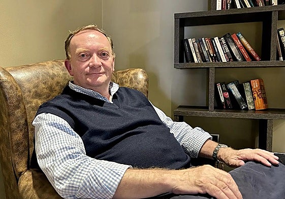 El autor, en un cómodo sofá, rodeado de libros.