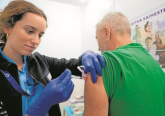 Una sanitaria inyecta una dosis de la vacuna de la gripe a un ciudadano.