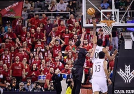 El rojinegro Zach Hankins intenta una penetración ante el merengue Lyles.